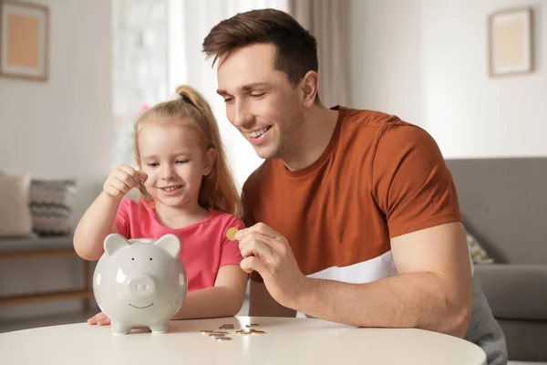 depositphotos_266257378-stock-photo-father-and-daughter-putting-coins